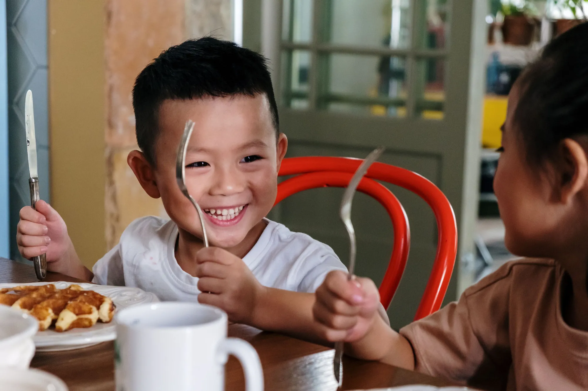 Zwei Kinder lachen beim Mittagessen